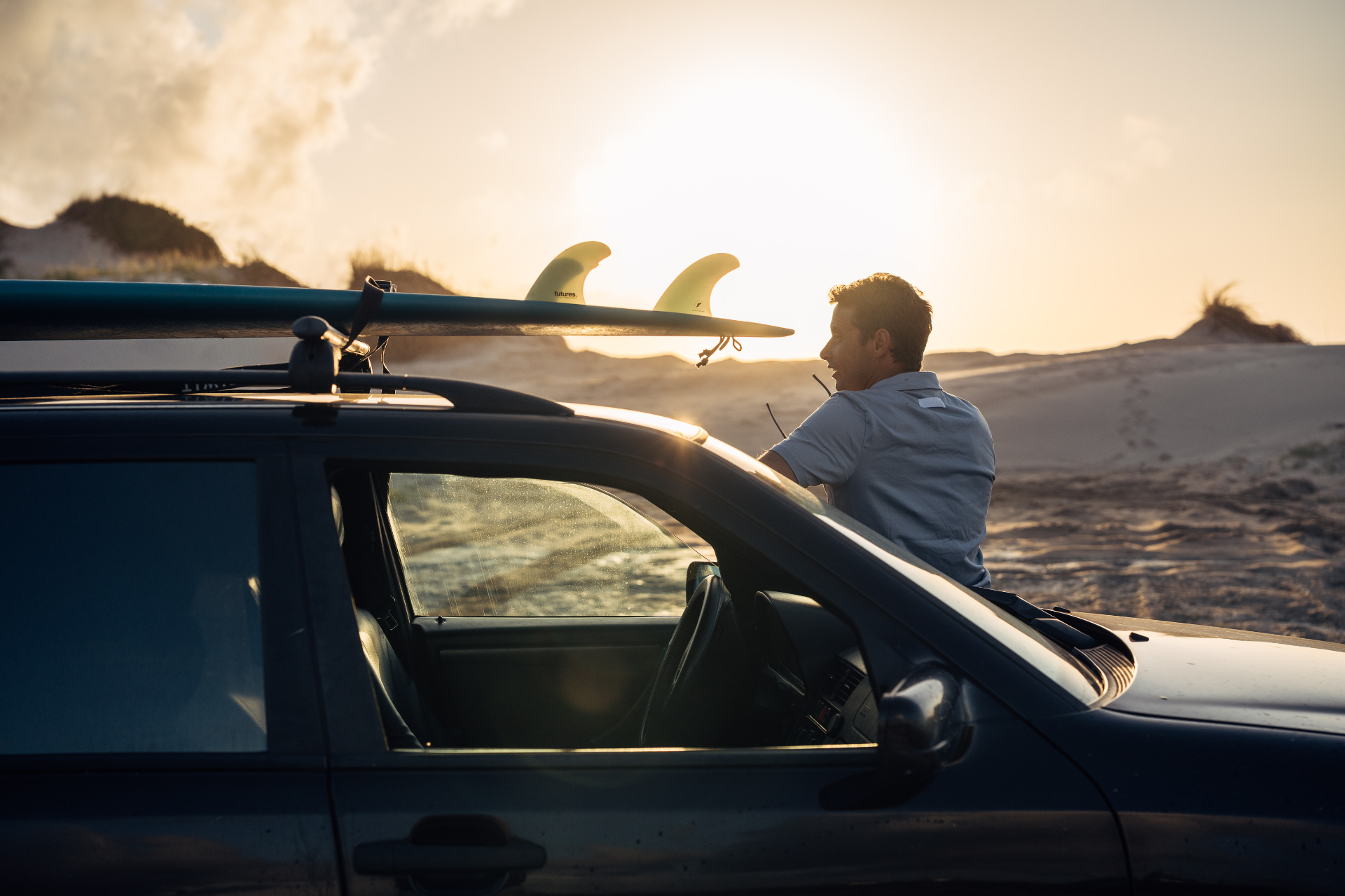Ivo Cação with surfboards and van at sunset in Figueira da Foz